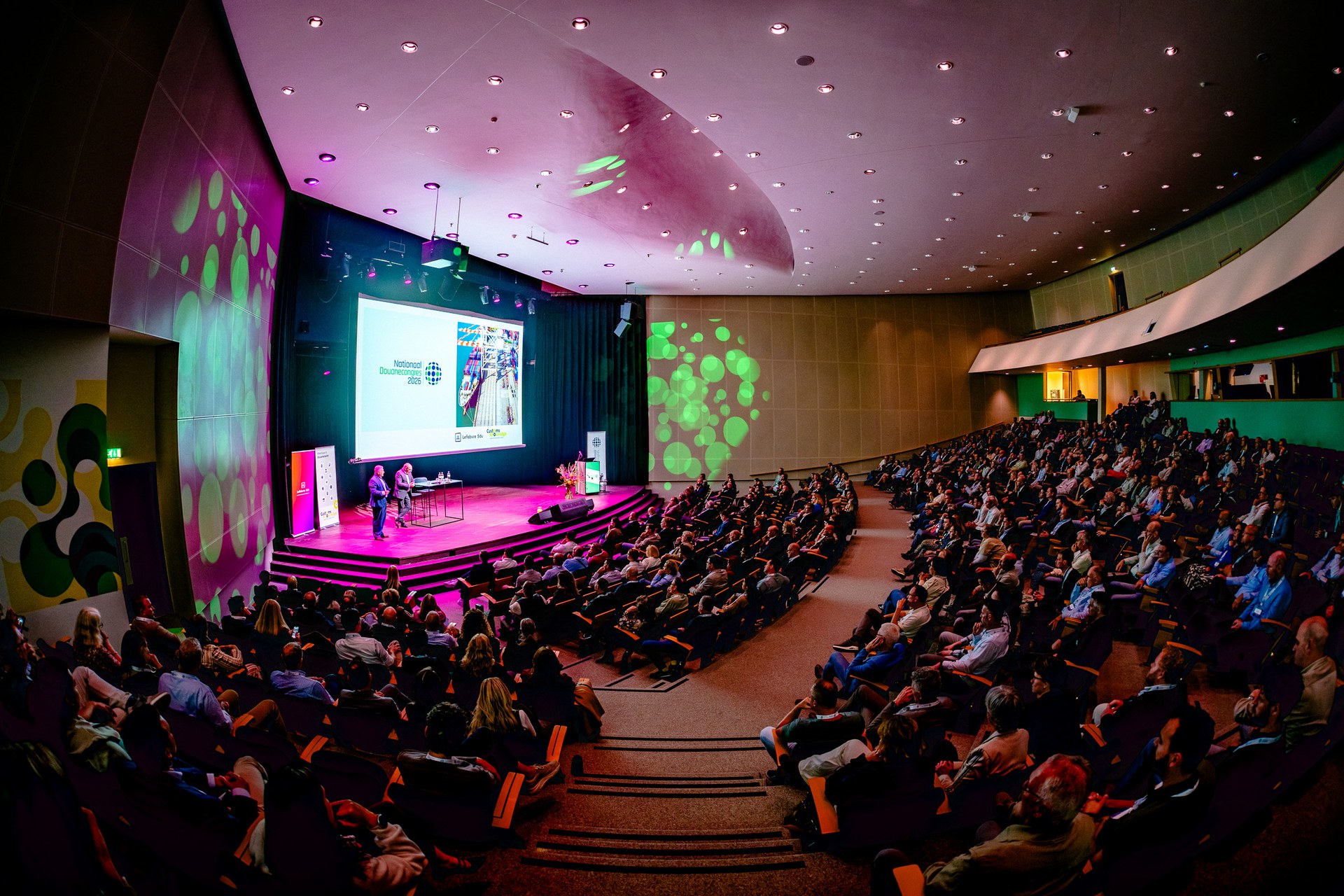 Overzicht van de congreszaal met podium en publiek. Nationaal Douanecongres 2026, Rotterdam. Fotografie: Leroy Beesemer, in samenwerking met Youngblood Productions.