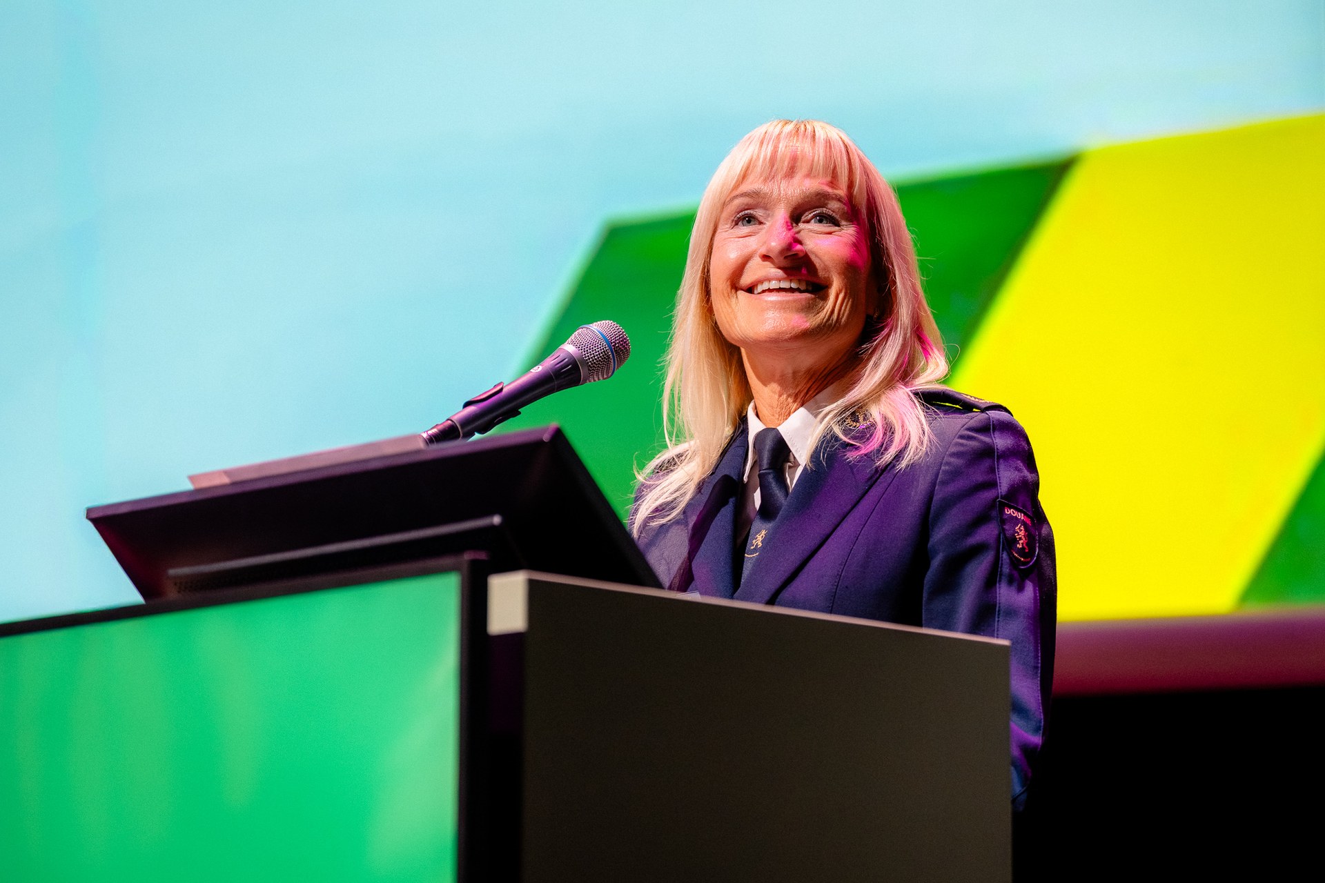Spreker achter het spreekgestoelte tijdens een presentatie. Nationaal Douanecongres 2026, Rotterdam. Fotografie: Leroy Beesemer, in samenwerking met Youngblood Productions.
