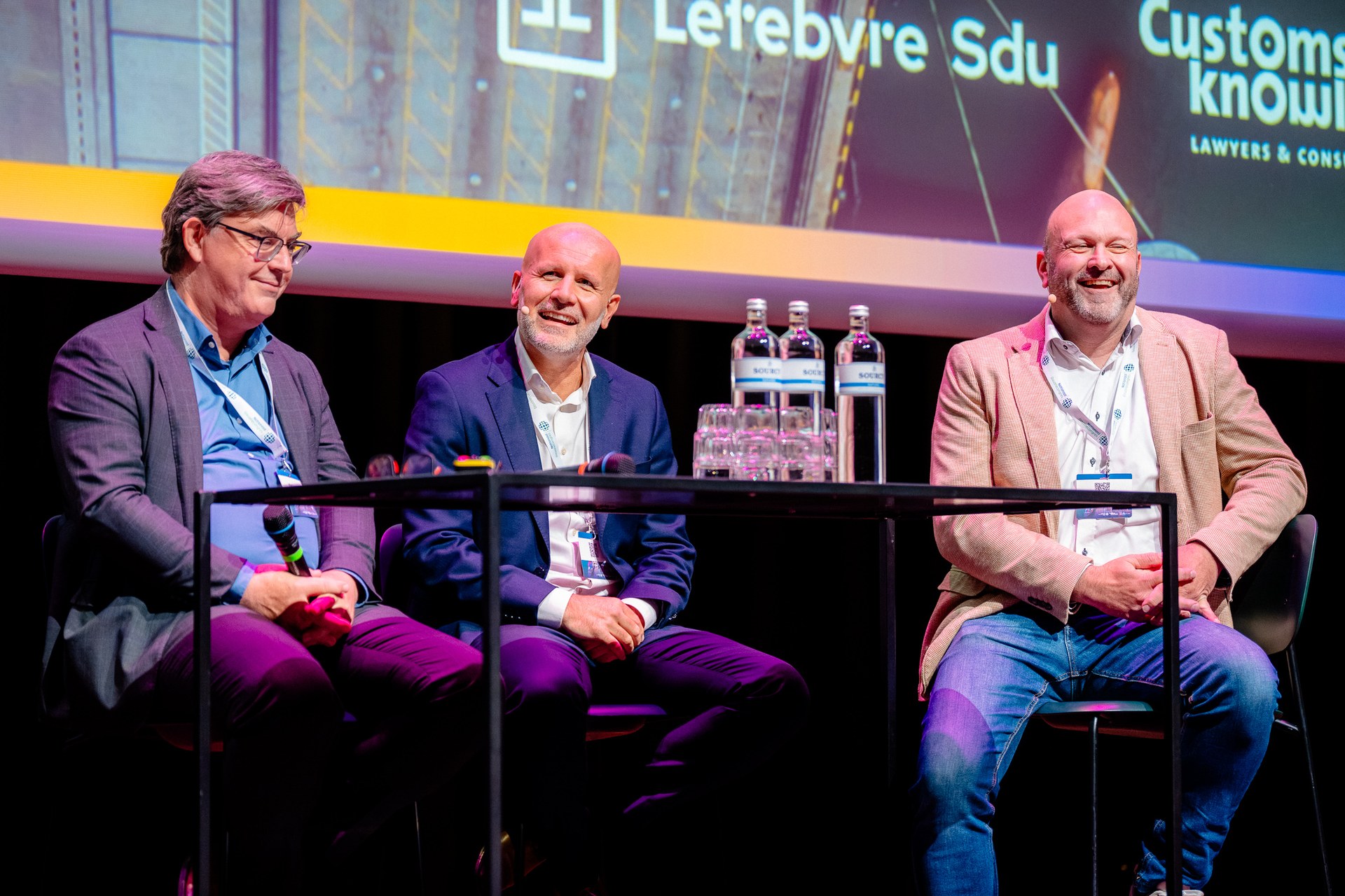 Ontspannen moment tijdens een panelgesprek op het podium. Nationaal Douanecongres 2026, Rotterdam. Fotografie: Leroy Beesemer, in samenwerking met Youngblood Productions.