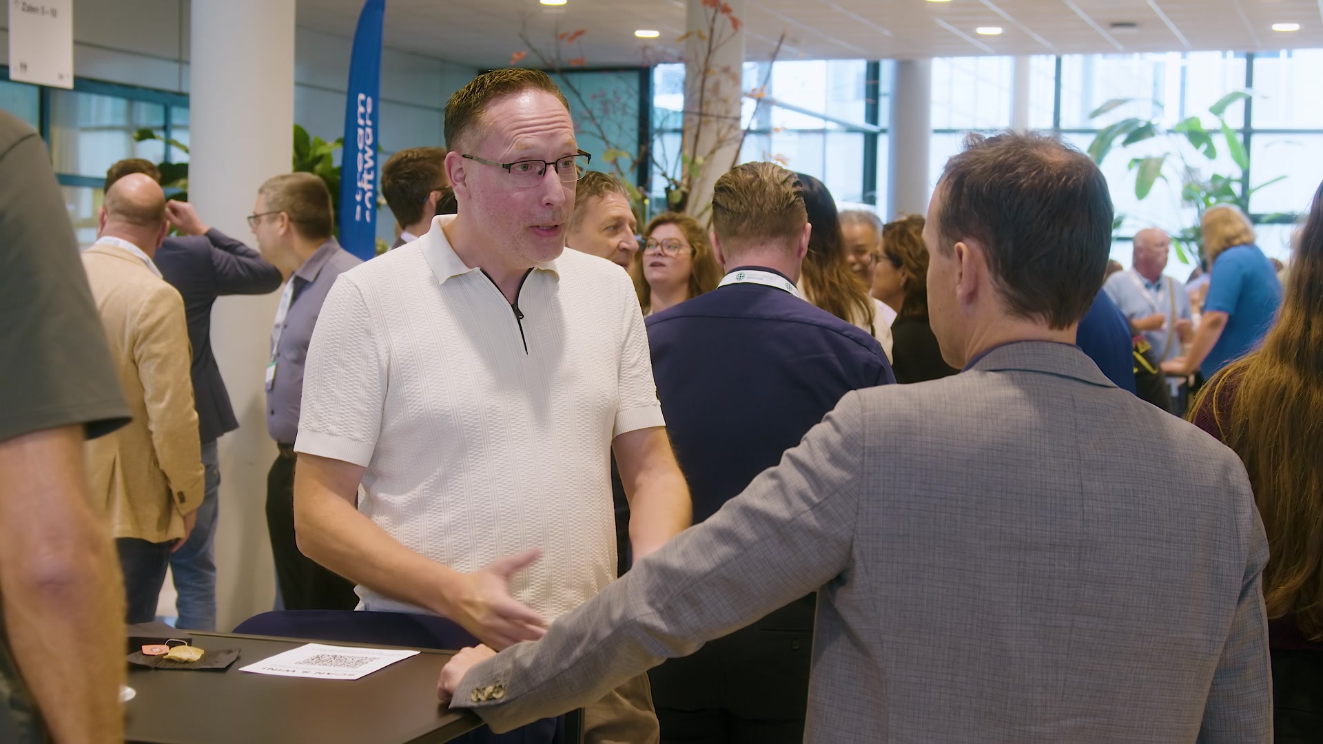 Bezoekers ontmoeten elkaar in de foyer tijdens het Nationaal Douanecongres 2026. Still uit de aftermovie van Youngblood Productions.