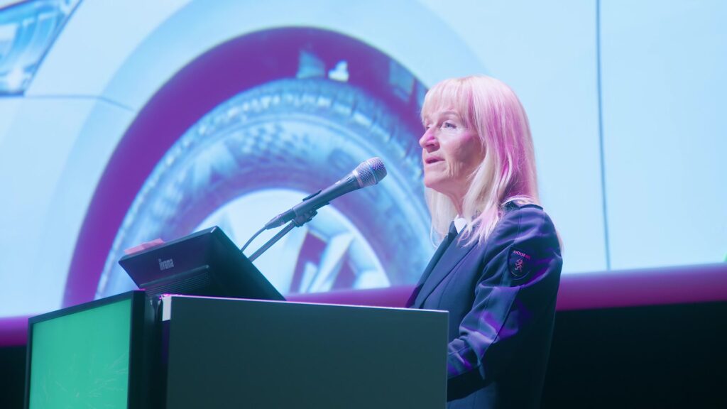 Spreker achter de microfoon tijdens het Nationaal Douanecongres 2026. Still uit de aftermovie van Youngblood Productions.